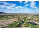 Scenic aerial view of the community and golf course with desert and mountain views under a beautiful blue sky at 21166 W Main St, Buckeye, AZ 85396