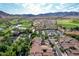 Aerial view showcasing a stunning golf course, parking lot, and charming homes nestled amongst lush greenery and majestic mountains at 21166 W Main St, Buckeye, AZ 85396