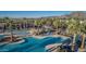 Aerial view of community pool area, lounge seating, mature trees, landscaping, and mountain views at 21166 W Main St, Buckeye, AZ 85396