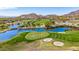 Scenic aerial view of lush green golf course with a tranquil lake and desert mountain views at 21166 W Main St, Buckeye, AZ 85396