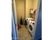 Functional laundry room with a washer, dryer, and overhead storage shelf at 21166 W Main St, Buckeye, AZ 85396