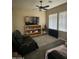 Cozy living room features comfortable seating, a ceiling fan, a large window and a television for relaxation at 21166 W Main St, Buckeye, AZ 85396