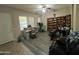 Spacious living room with wood-style flooring, desk, ceiling fan, and a built-in bookshelf at 21166 W Main St, Buckeye, AZ 85396