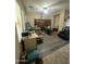 Spacious living room with wood-style flooring, desk, ceiling fan, and a built-in bookshelf at 21166 W Main St, Buckeye, AZ 85396