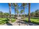 Scenic view of a lush park with palm trees leading to a charming building at 21166 W Main St, Buckeye, AZ 85396
