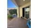 Covered brick patio with blue chairs, table, garden and sliding glass door at 21166 W Main St, Buckeye, AZ 85396