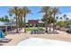 Inviting community pool area featuring lounge chairs, mature palm trees, covered lounge area, and manicured lawn at 21166 W Main St, Buckeye, AZ 85396