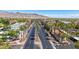 An elevated street view shows a road lined with lush palm trees and diverse architecture framed by desert landscape and clear blue skies at 21166 W Main St, Buckeye, AZ 85396