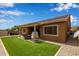 A well-maintained backyard with turf and desert landscaping features an inviting covered patio area at 24327 N 163Rd Dr, Surprise, AZ 85387