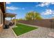 Well maintained backyard with artificial turf, desert landscaping, and a covered patio area at 24327 N 163Rd Dr, Surprise, AZ 85387