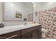 Bright bathroom featuring a vanity with a modern sink, framed mirror and decorative floral shower curtain at 24327 N 163Rd Dr, Surprise, AZ 85387