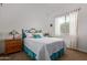 Well-lit bedroom featuring a comfortable bed, wooden nightstand, and bright window with sheer curtains at 24327 N 163Rd Dr, Surprise, AZ 85387
