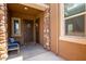 Inviting covered entryway with charming decor, a cozy bench, and a decorative stone accent wall at 24327 N 163Rd Dr, Surprise, AZ 85387