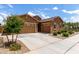 Attractive single-story home featuring a three-car garage, desert landscaping, and a charming stone accent at 24327 N 163Rd Dr, Surprise, AZ 85387