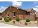 Charming single-story home with manicured desert landscaping, a stone accent wall, and a backyard patio at 24327 N 163Rd Dr, Surprise, AZ 85387