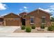 Charming single-story home features a two-car garage, manicured desert landscaping, and a stone front accent at 24327 N 163Rd Dr, Surprise, AZ 85387
