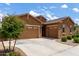 Attractive single-story home featuring a three-car garage, desert landscaping, and a charming stone accent at 24327 N 163Rd Dr, Surprise, AZ 85387