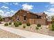 Charming single-story home with manicured desert landscaping, a stone accent wall, and a backyard patio at 24327 N 163Rd Dr, Surprise, AZ 85387
