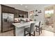 A well-lit kitchen with stainless steel appliances, dark wood cabinets, and a center island with barstool seating at 24327 N 163Rd Dr, Surprise, AZ 85387