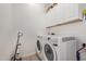 Well-organized laundry room with modern white appliances and ample storage space, offering convenience at 24327 N 163Rd Dr, Surprise, AZ 85387