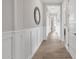 Long hallway with wainscoting and light wood-look tile flooring, with doors on both sides at 2546 E Russell St, Mesa, AZ 85213