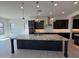 Stunning kitchen features an oversized granite island, stainless hood, and sleek dark cabinetry at 2546 E Russell St, Mesa, AZ 85213
