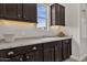 Functional laundry room with dark cabinets, granite countertop, and a sink with a view at 2546 E Russell St, Mesa, AZ 85213
