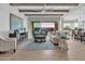 Bright living room boasts wood beam ceilings, stylish furniture, and sliding glass doors to outdoor space at 2546 E Russell St, Mesa, AZ 85213