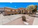 Single-story home showcasing desert landscaping, light beige stucco, and a tile roof under a bright blue sky at 2635 E Riviera Dr, Chandler, AZ 85249