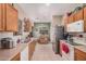 Eat-in kitchen features tile floors, stainless steel appliances, light wood cabinetry, and window with blinds at 2635 E Riviera Dr, Chandler, AZ 85249