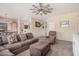 Living room with plush sectional sofa, ceiling fan, neutral tones, and view into the dining area and kitchen at 2635 E Riviera Dr, Chandler, AZ 85249