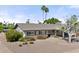 Inviting single-story home showcases xeriscaping, a covered carport, and brick accents for curb appeal at 2902 E Corrine Dr, Phoenix, AZ 85032