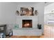 Close-up of a white brick fireplace with a lit fire and decorative accents at 2902 E Corrine Dr, Phoenix, AZ 85032