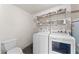 Functional laundry room with modern washer, dryer, shelving and toilet at 2902 E Corrine Dr, Phoenix, AZ 85032