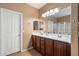 A well-lit bathroom with a double sink vanity, wood cabinets, and a clean glass-enclosed shower at 3003 E Ironside Ln, Gilbert, AZ 85298