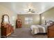 An elegant bedroom with classic wooden furnishings, a ceiling fan, and bright natural light at 3003 E Ironside Ln, Gilbert, AZ 85298
