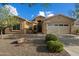 Inviting single-story home with desert landscaping, a two-car garage, and a neutral-toned exterior under a clear blue sky at 3003 E Ironside Ln, Gilbert, AZ 85298