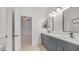 Modern bathroom with dual sinks, gray vanity, and tile flooring at 3166 E Desert Willow Rd, Phoenix, AZ 85048