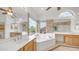 Bright bathroom featuring dual sinks, a luxurious soaking tub, and large mirrors at 3166 E Desert Willow Rd, Phoenix, AZ 85048