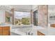 Bright bathroom showcasing bathtub with tiled walls, and large windows offering plenty of natural light at 3166 E Desert Willow Rd, Phoenix, AZ 85048