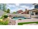 Inviting backyard pool area with rock waterfall feature and lush landscaping, perfect for outdoor relaxation at 3166 E Desert Willow Rd, Phoenix, AZ 85048