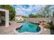 Inviting backyard pool with a rock waterfall feature, surrounded by lush landscaping and a paved patio at 3166 E Desert Willow Rd, Phoenix, AZ 85048