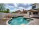 Stunning backyard pool with rock features, mature landscaping, and inviting outdoor lighting for evening enjoyment at 3166 E Desert Willow Rd, Phoenix, AZ 85048