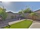 Enclosed backyard with artificial turf, a brick border, landscaping, and a decorative piece at 3319 W Carter Rd, Phoenix, AZ 85041