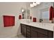 Bathroom with a dual sink vanity with a dark wood finish and large mirror with modern lighting at 3319 W Carter Rd, Phoenix, AZ 85041