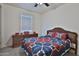 Neutral bedroom featuring wood furniture, carpet and a bed with a blue, red and white quilt at 3319 W Carter Rd, Phoenix, AZ 85041
