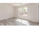 Bright, sunlit bedroom with gray wood-look flooring and a large window with backyard views at 3532 S 160Th Ln, Goodyear, AZ 85338