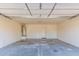 An empty two-car garage with a hot water tank and access door at 3532 S 160Th Ln, Goodyear, AZ 85338