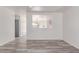 Bright, open-concept living room with wood-look floors and a large window looking into the kitchen at 3532 S 160Th Ln, Goodyear, AZ 85338