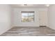 Bright living area featuring wood-look flooring, large window and access to the front door at 3532 S 160Th Ln, Goodyear, AZ 85338